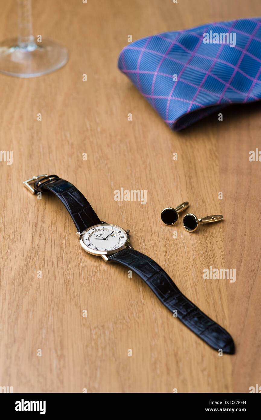 Montre-bracelet, Cravate et Boutons de manchette disposés sur une table en chêne. Banque D'Images