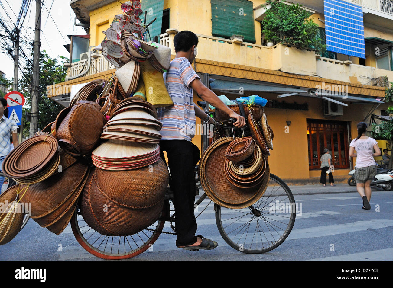 L'homme sur un vélo de paille vente bols et chapeaux, Hanoi, Vietnam Banque D'Images