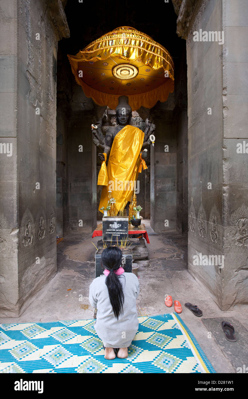 Femme adorant une statue de Vishnu. Angkor Wat. Cambodge Banque D'Images
