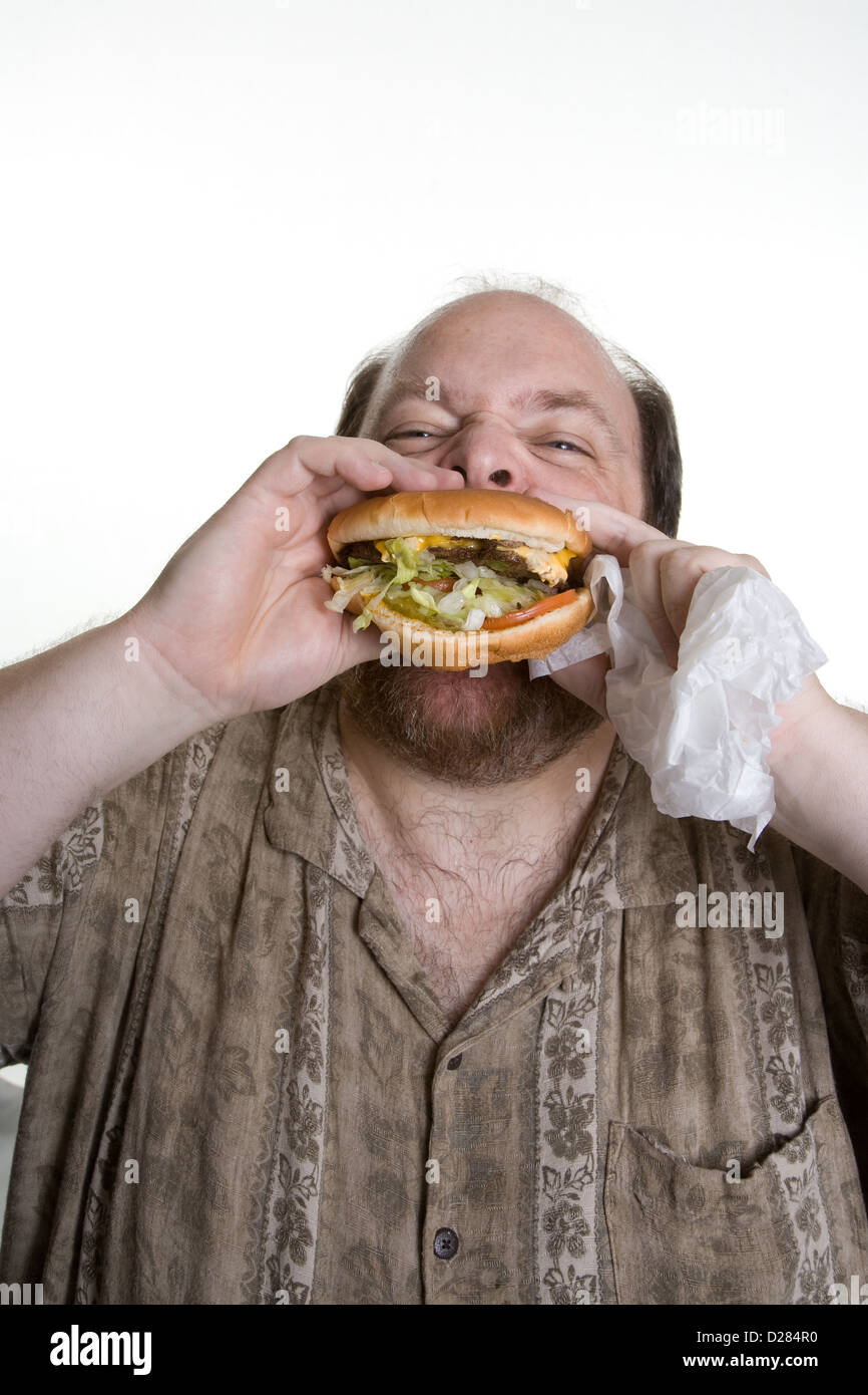 L'excès de l'homme dans la mi-quarantaine eating fast food Banque D'Images