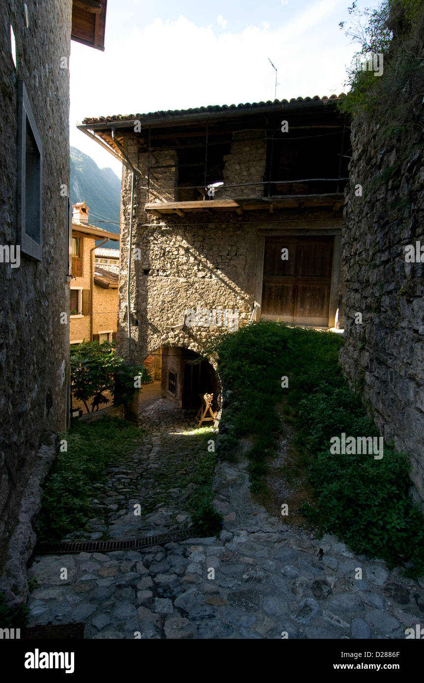 Les murs bien conservés, la porte principale et l'arche menant au village médiéval de montagne rural de 'Tenno', avec un château privé Banque D'Images