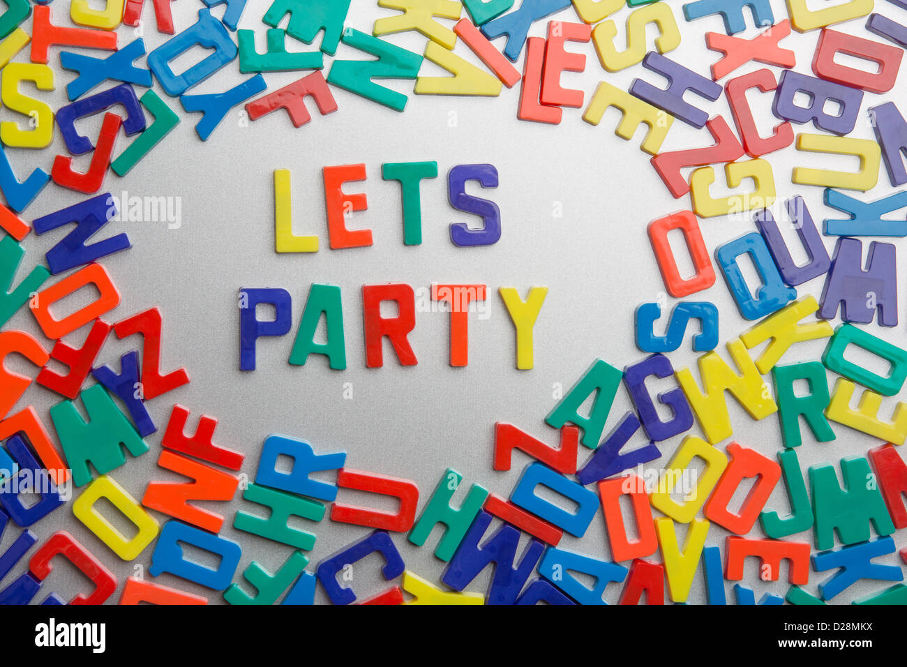 "Let's Party' - aimants pour réfrigérateur messages sort sur un fouillis de lettres Banque D'Images