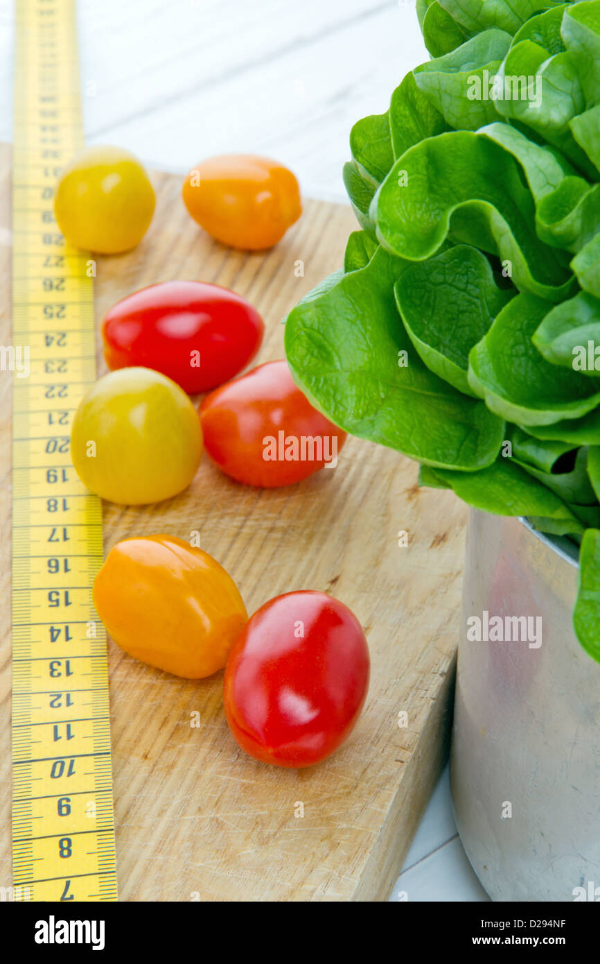 Tomates, salade et bande de mesure - régime alimentaire et la saine alimentation ; concept de perte de poids Banque D'Images