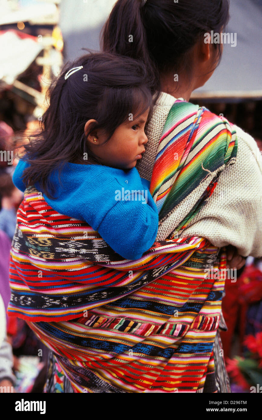 Guatemala, Chichicastenango. Femme portant son enfant dans le dos de manière traditionnelle. Banque D'Images