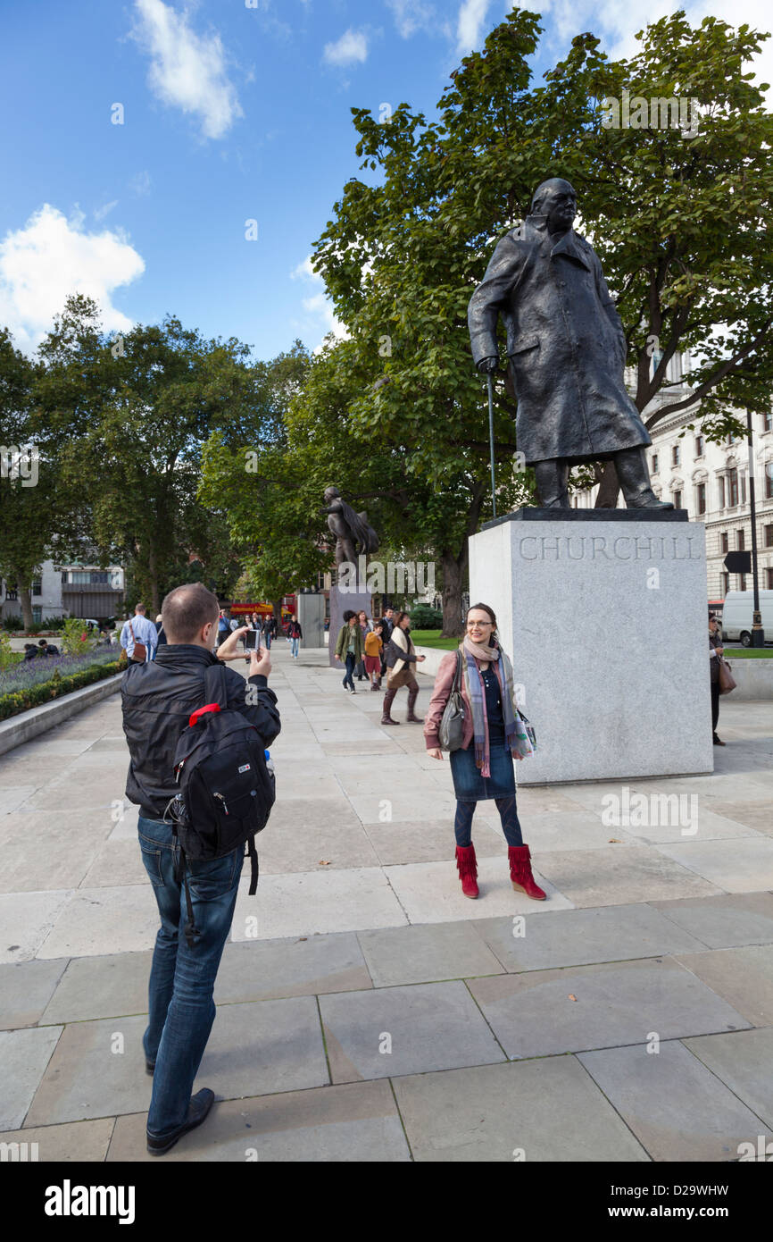 Photographies touristiques une femme devant la statue de Winston Churchill à la place du Parlement, Londres. Banque D'Images