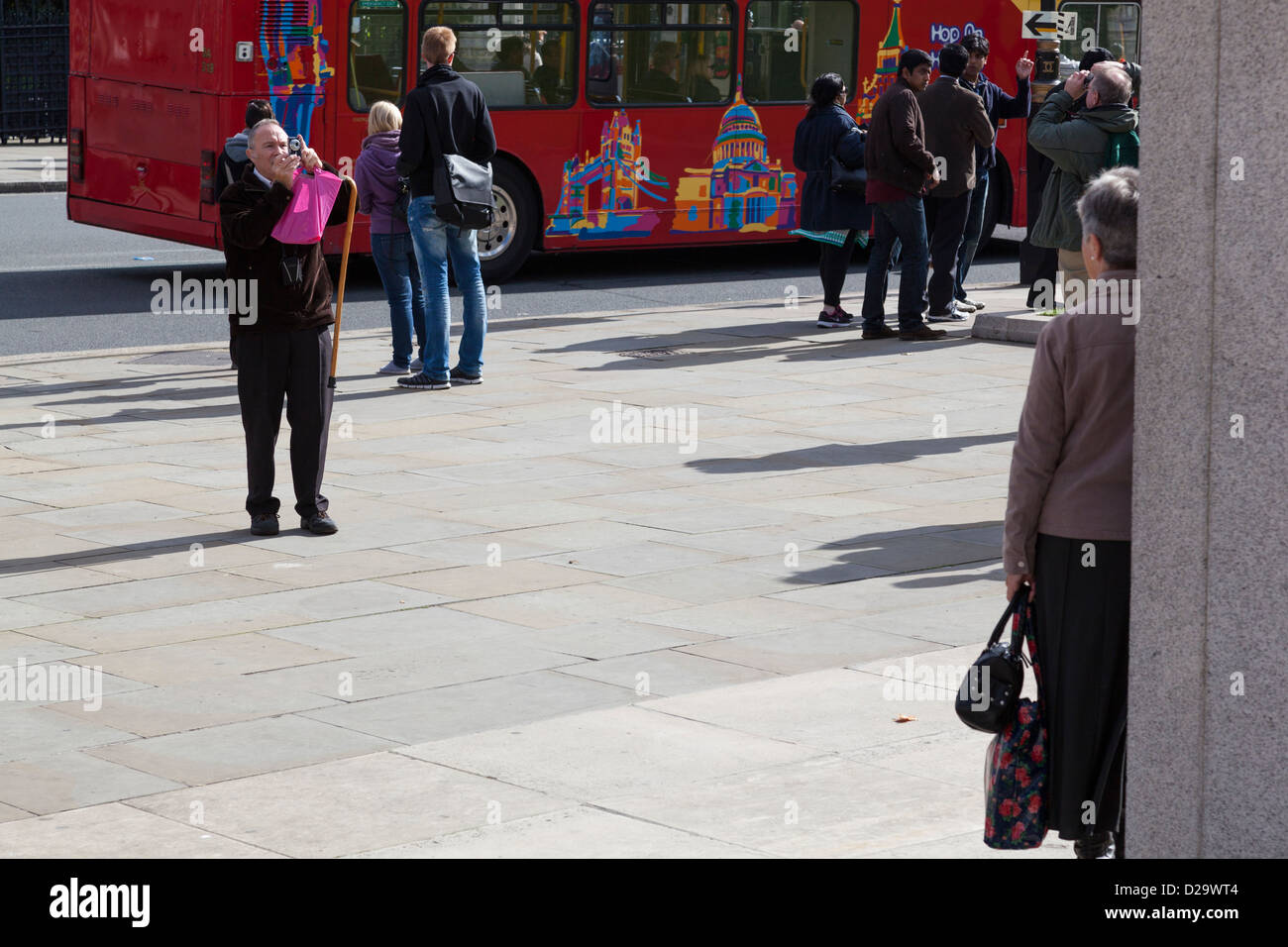 Un homme prend une photo d'une dame de la place du Parlement, Londres. Banque D'Images