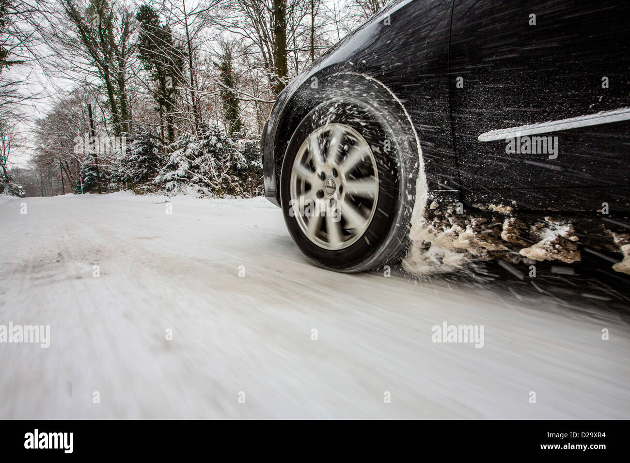 Voiture avec des pneus d'hiver sur une rue, entièrement recouvert de neige. Banque D'Images