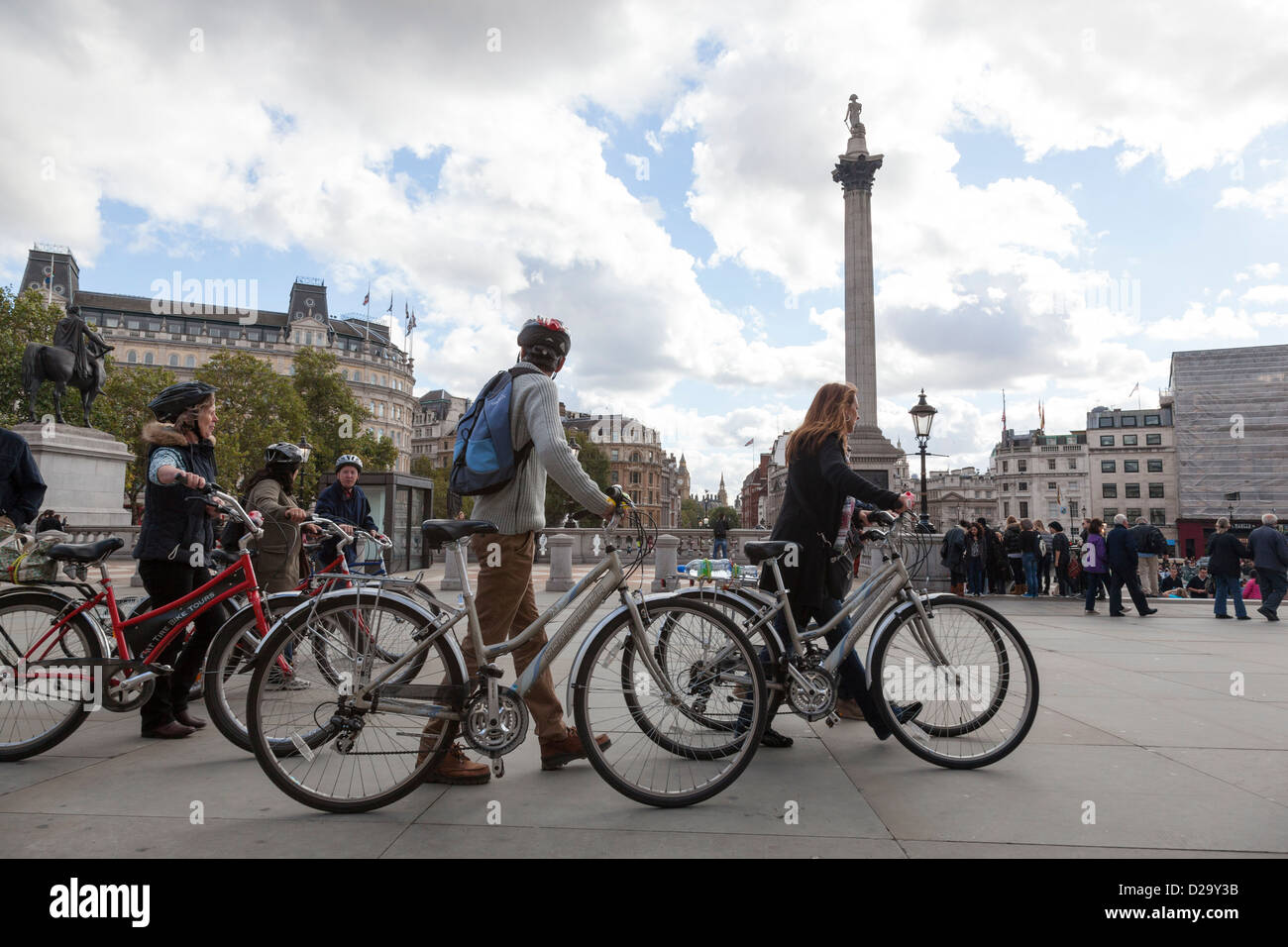 Groupe de touristes pousser leur vélo sur Trafalgar Square, Londres. Banque D'Images