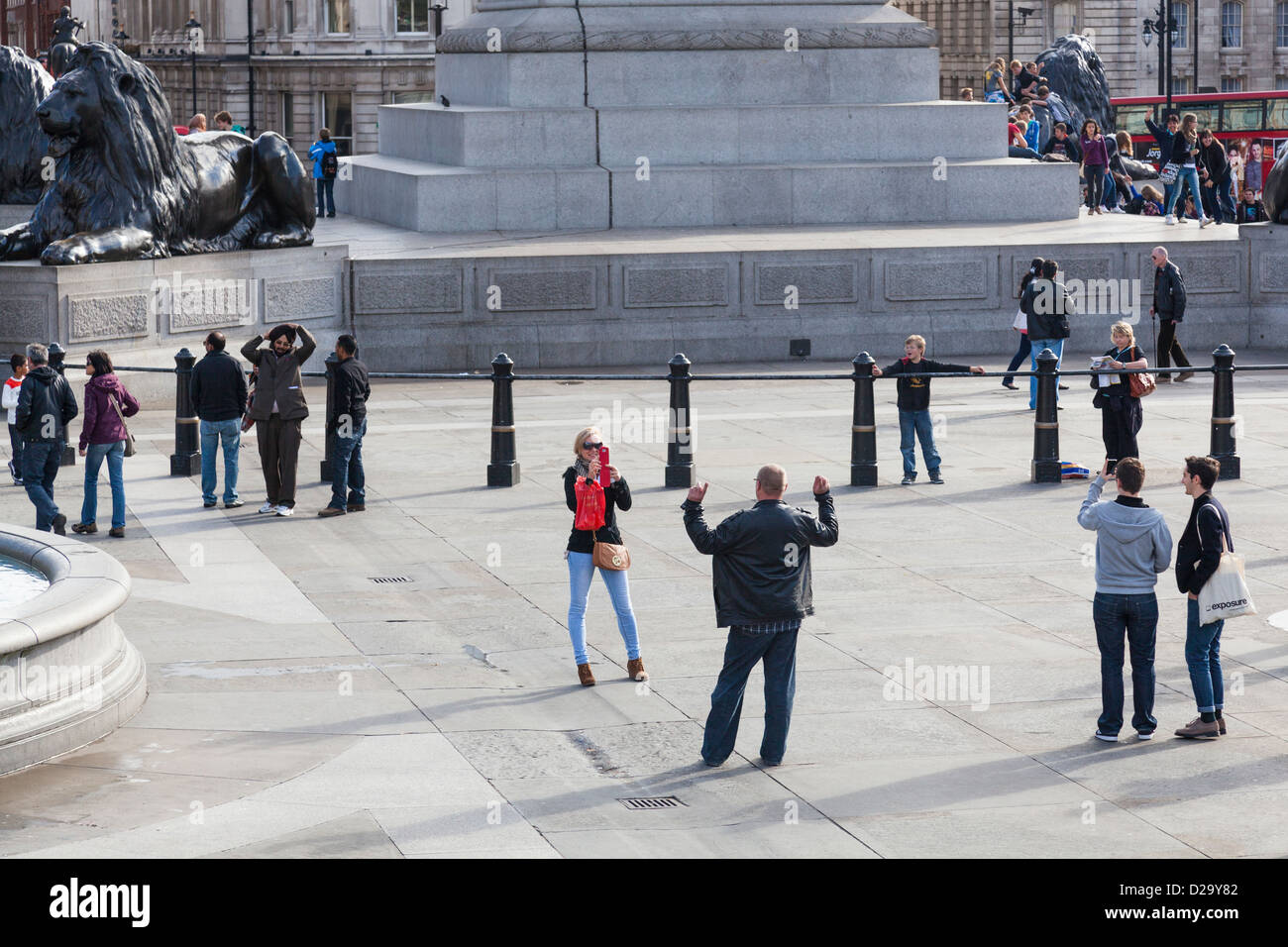 Touriste utilise son téléphone portable pour prendre une photo d'un homme à Trafalgar Square, Londres. Banque D'Images