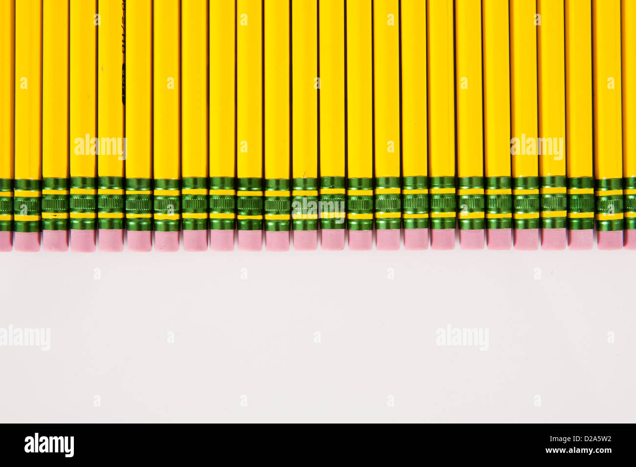 Une ligne de jaune, numéro 2 gommes crayon alignés sur un fond blanc. Banque D'Images