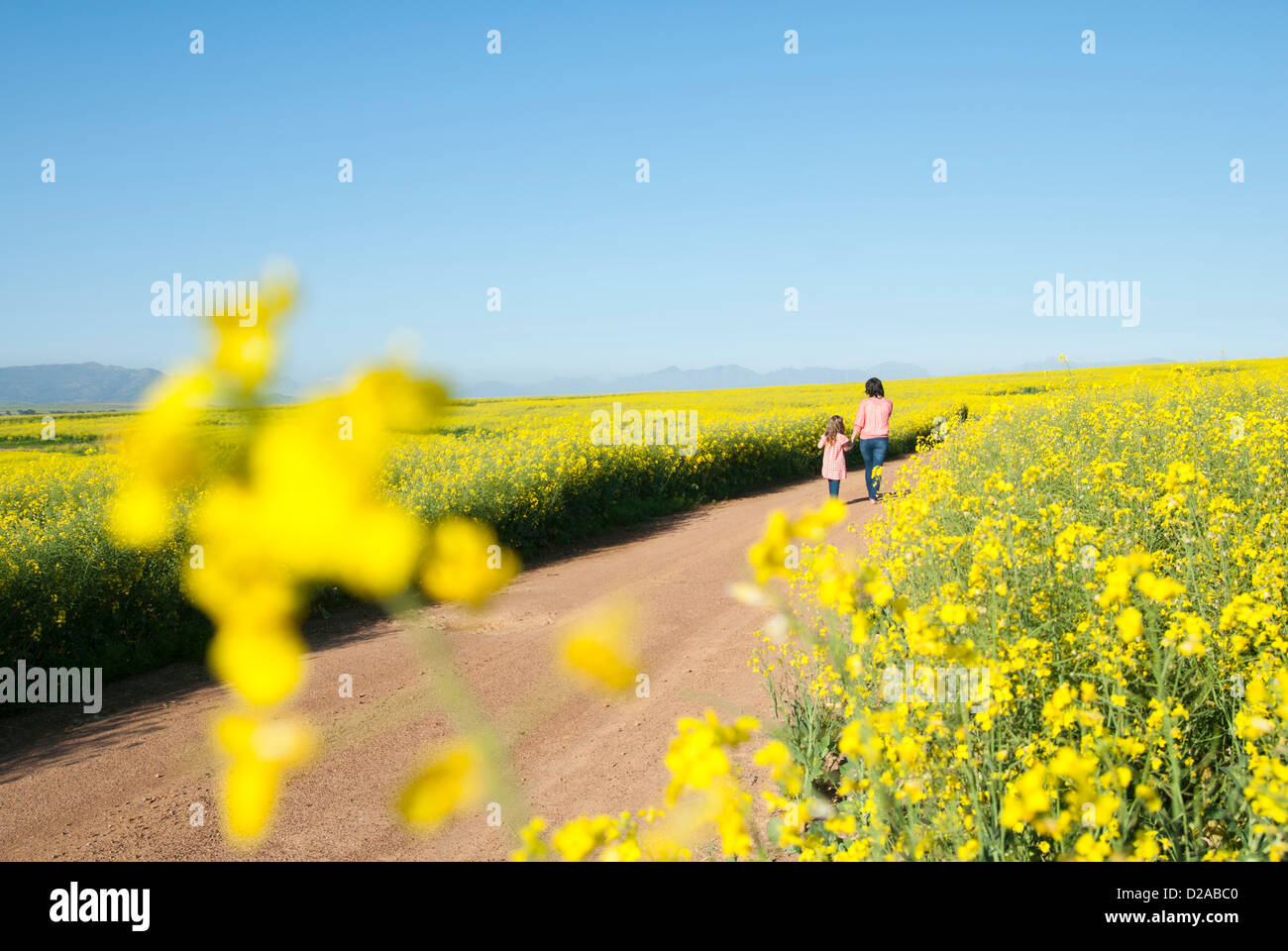 Mère et fille marche sur route de terre Banque D'Images