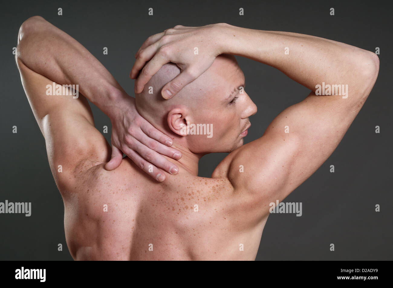 Portrait de naked athletic homme posant sur fond gris Banque D'Images