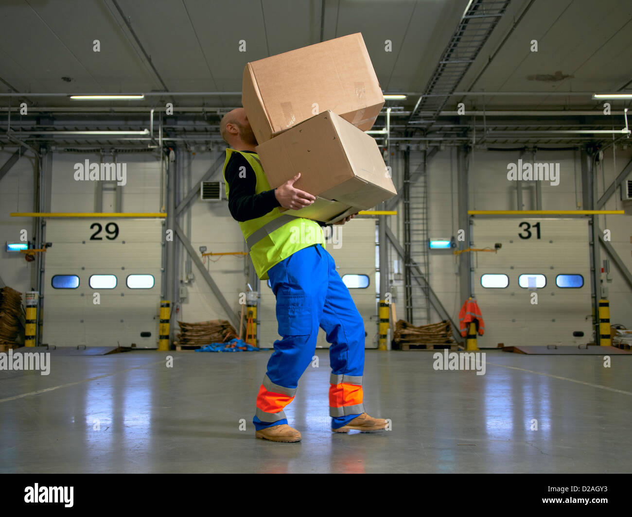 Worker carrying boxes in warehouse Banque D'Images