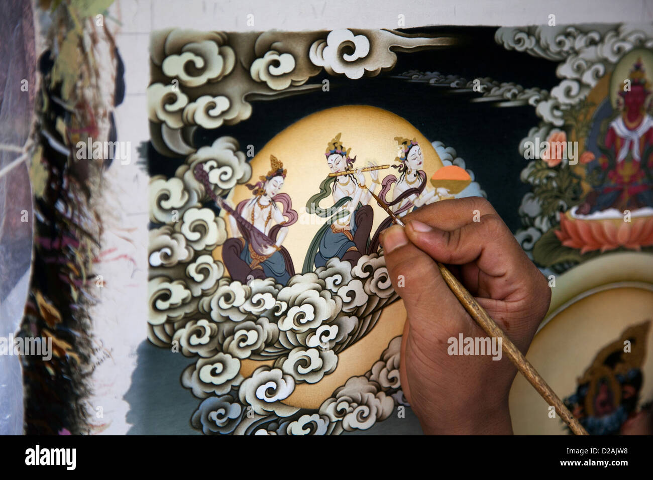 Un peintre peint détails complexes à l'aide de peintures d'or. Peinture mandala népalais traditionnel dans une galerie à Bhaktapur. Banque D'Images