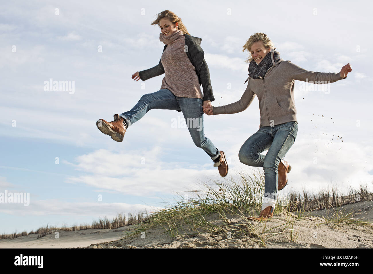 Smiling women running on beach Banque D'Images Smiling women running on beach Banque D'Images