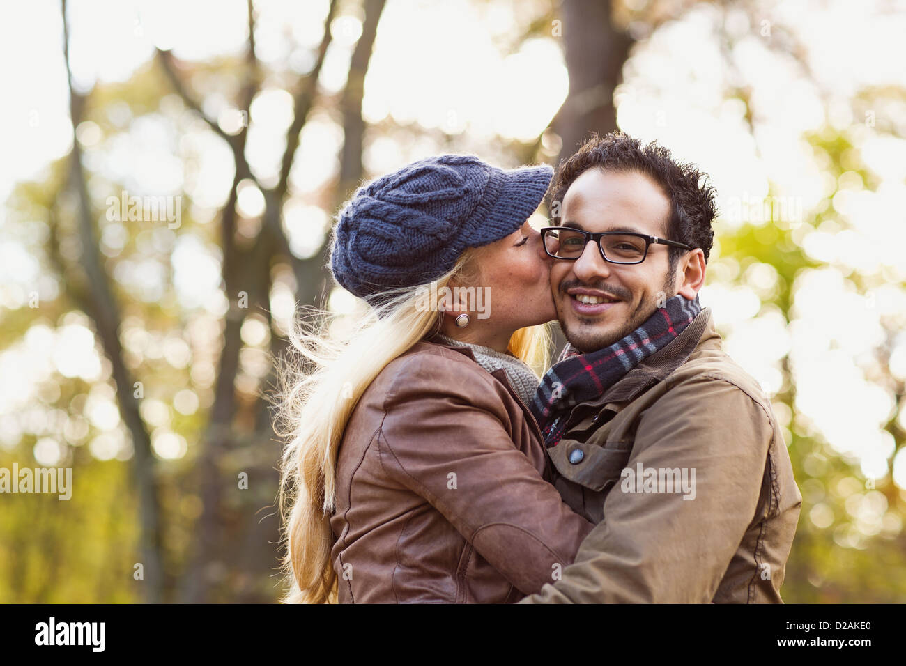 Smiling couple kissing in forest Banque D'Images Smiling couple kissing in forest Banque D'Images