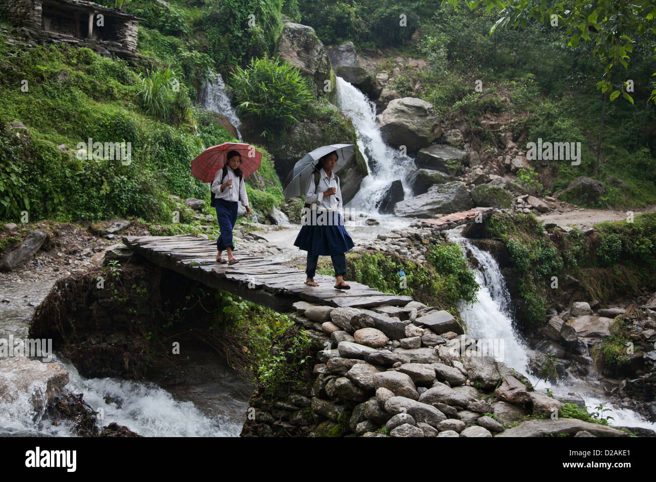 Deux filles de l'école font leur chemin à la maison après l'école le long d'une route de montagne dans le district de Dolakha. Banque D'Images