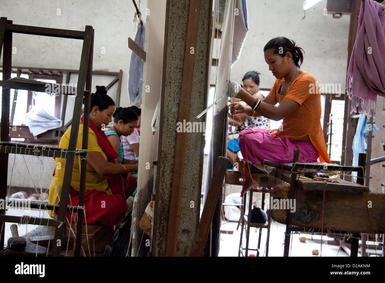 Les tisserands à Amity Tapis siéger par leur travail à tisser sur tissage de tapis en fonction de conception complexes. Banque D'Images Les tisserands à Amity Tapis siéger par leur travail à tisser sur tissage de tapis en fonction de conception complexes. Banque D'Images