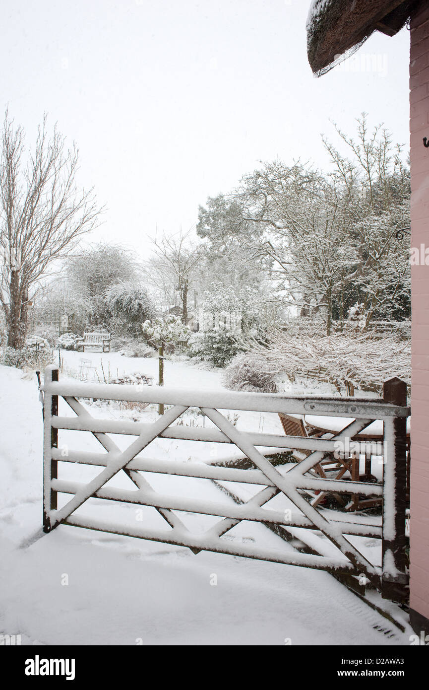 Le jardin couvert de neige vue à travers une porte de cinq barres Micheldever Hampshire England UK Banque D'Images