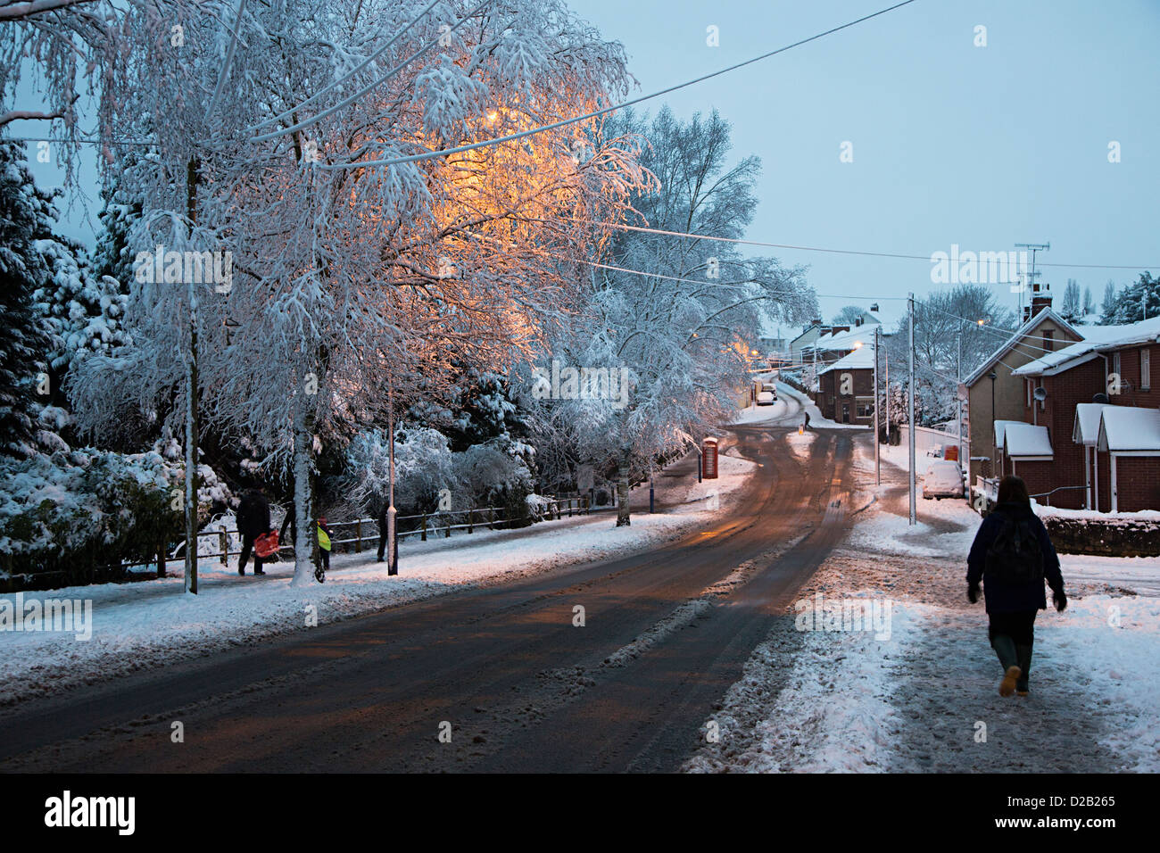 Les gens qui marchent dans la neige au crépuscule dans la ville de Abergavenny, Pays de Galles, Royaume-Uni Banque D'Images