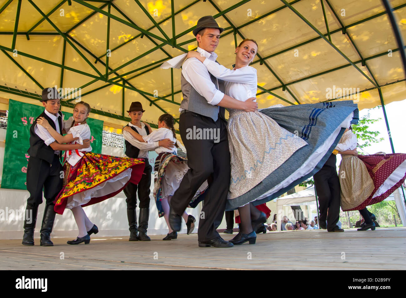 Les jeunes gens qui font de la danse folklorique hongroise traditionnelle en costume traditionnel Banque D'Images