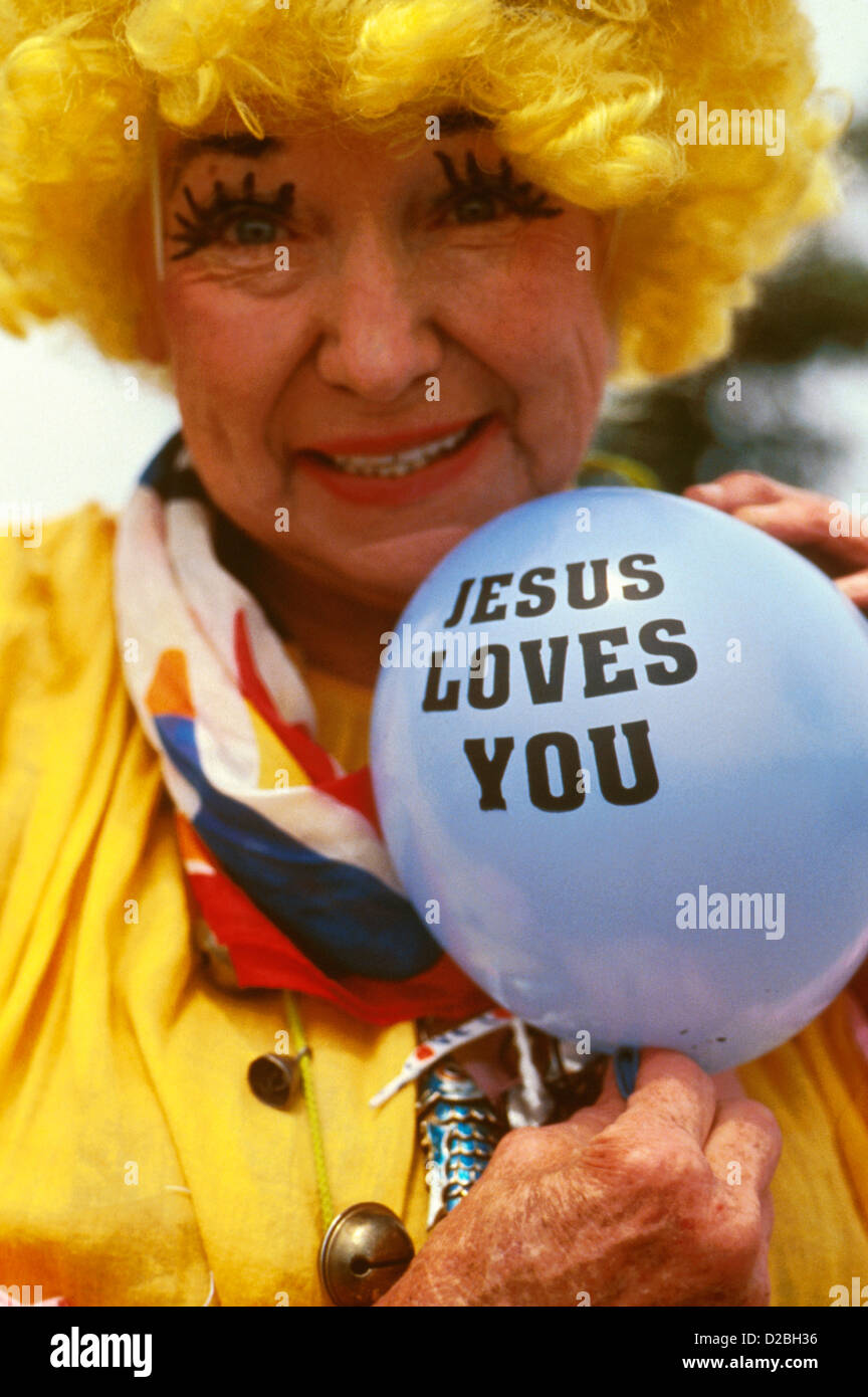 Female Clown Holding Balloon : Jésus vous aime Banque D'Images