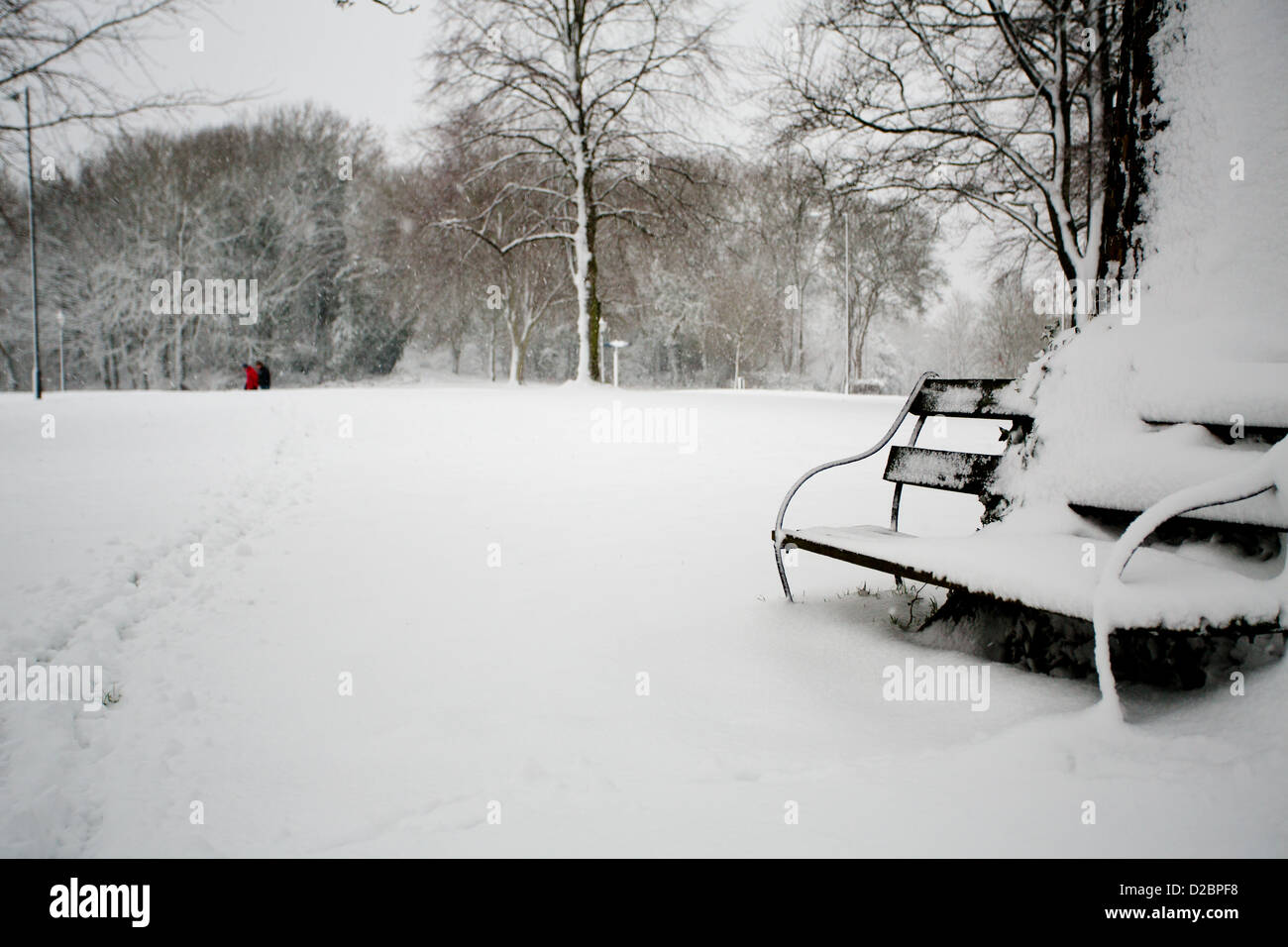 Deux hommes les éléments de renfort de faire une promenade dans la neige. Banc avec Banque D'Images
