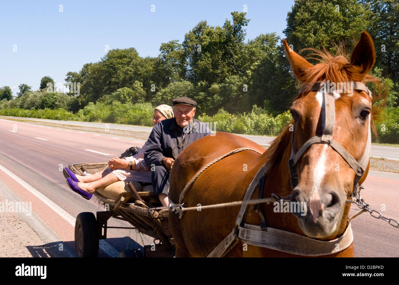 Équitation sur couple d'agriculteurs en panier sur la route de Kiev à Lviv en Ukraine Banque D'Images