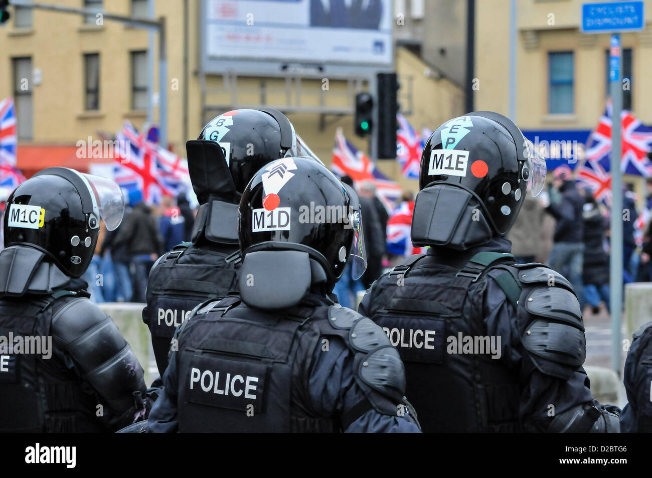 19 janvier 2013. Belfast, en Irlande du Nord - TSG (PSNI Riot Squad) regardez comme un grand groupe de manifestants loyalistes à pied passé transportant des drapeaux de l'Union européenne. Banque D'Images