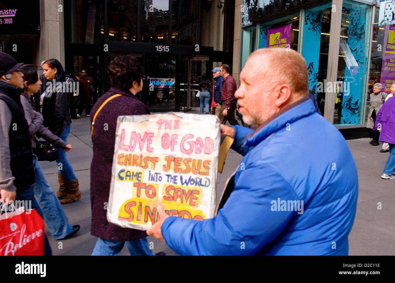 Man Holding signe religieux à Times Square, New York City Banque D'Images