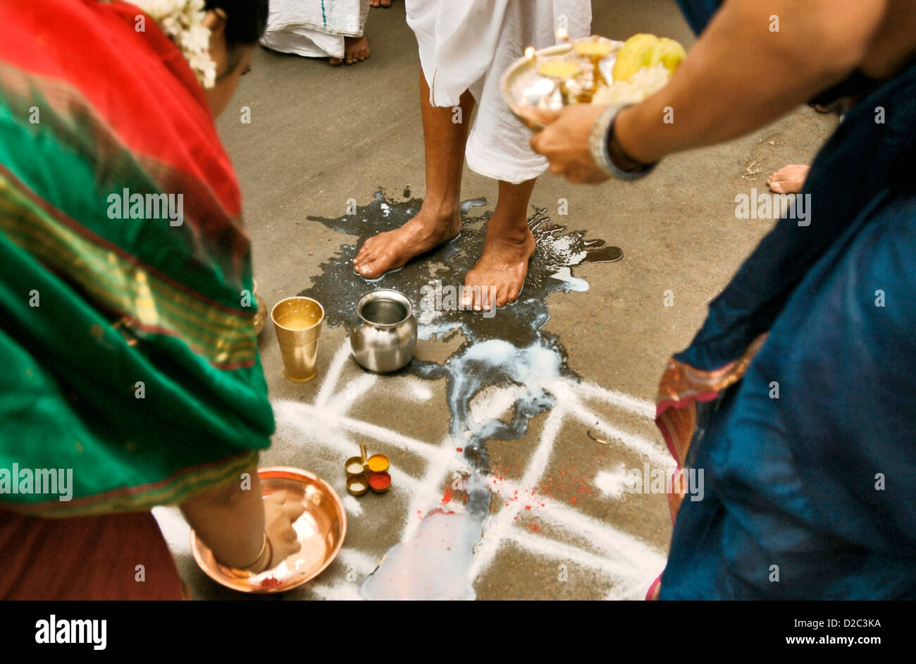 Les femmes croyants laver les pieds de la tête de prêtre dans les rues de Poona avant la Procession Palkhi, Poona, Maharashtra, Inde Banque D'Images