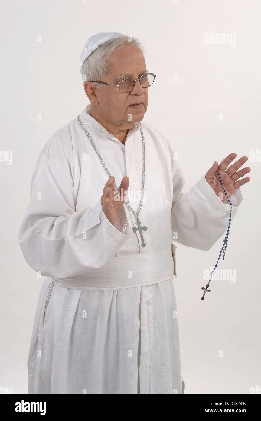 Homme habillé en robe blanche et chapeau de prière. Holding Rosary Banque D'Images