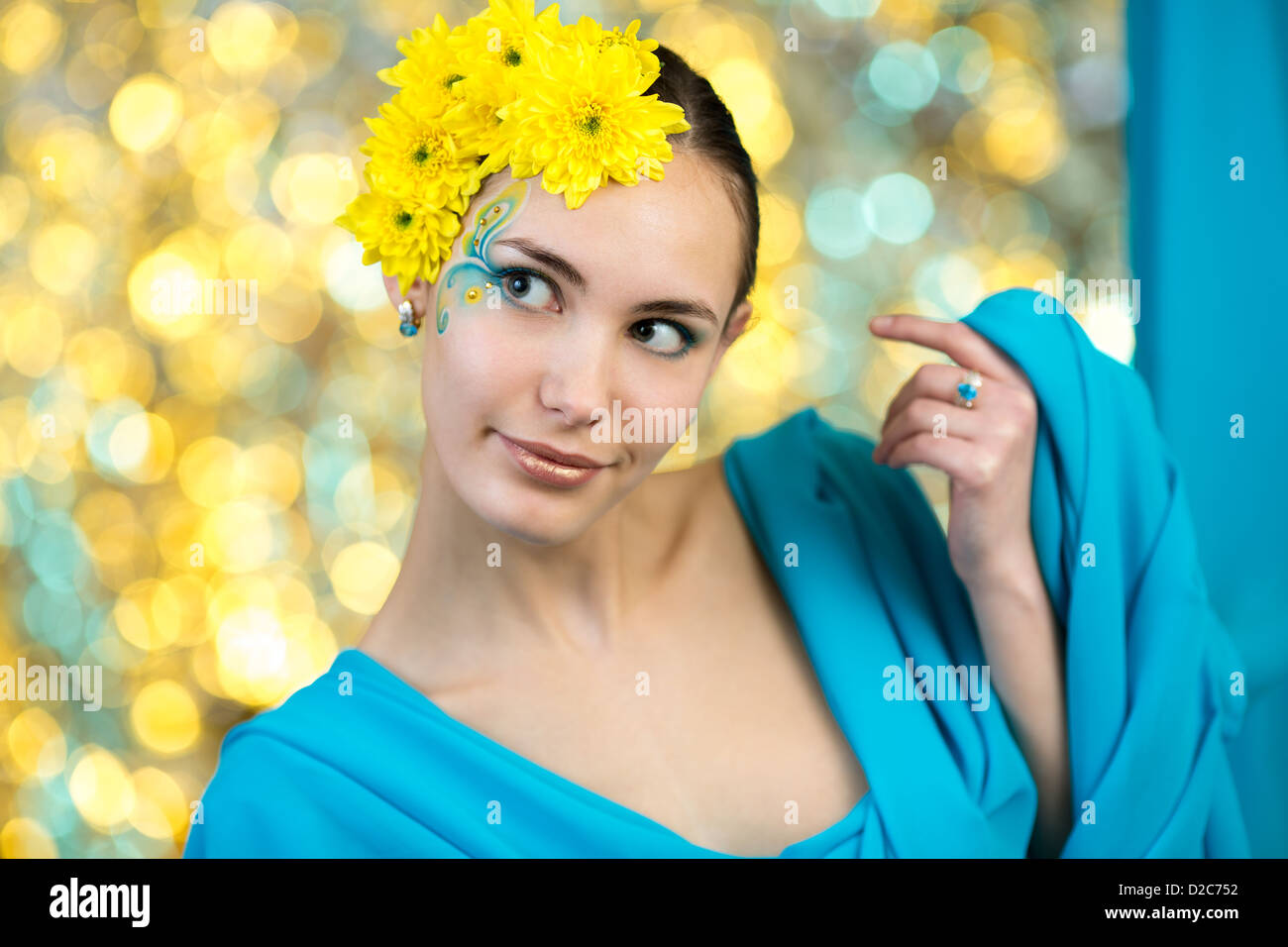 Jeune modèle avec le maquillage et les fleurs dans les cheveux Banque D'Images
