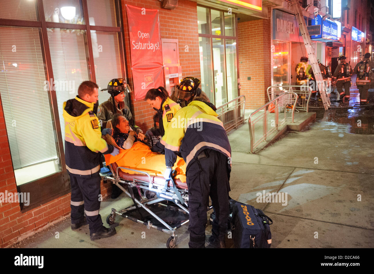 Toronto, le 20 Jan 2013 PEUT, - les pompiers et Toronto EMS évaluer un résident après avoir été sauvé d'un incendie. Les ambulanciers traités une femme âgée après un 2-alarme incendie au 3266, rue Yonge, au nord du Saint-Laurent. Banque D'Images