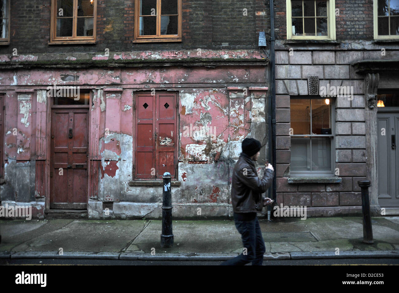Man Walking cours des vieux bâtiments géorgiens Princelett Spitalfields Street Londres Banque D'Images