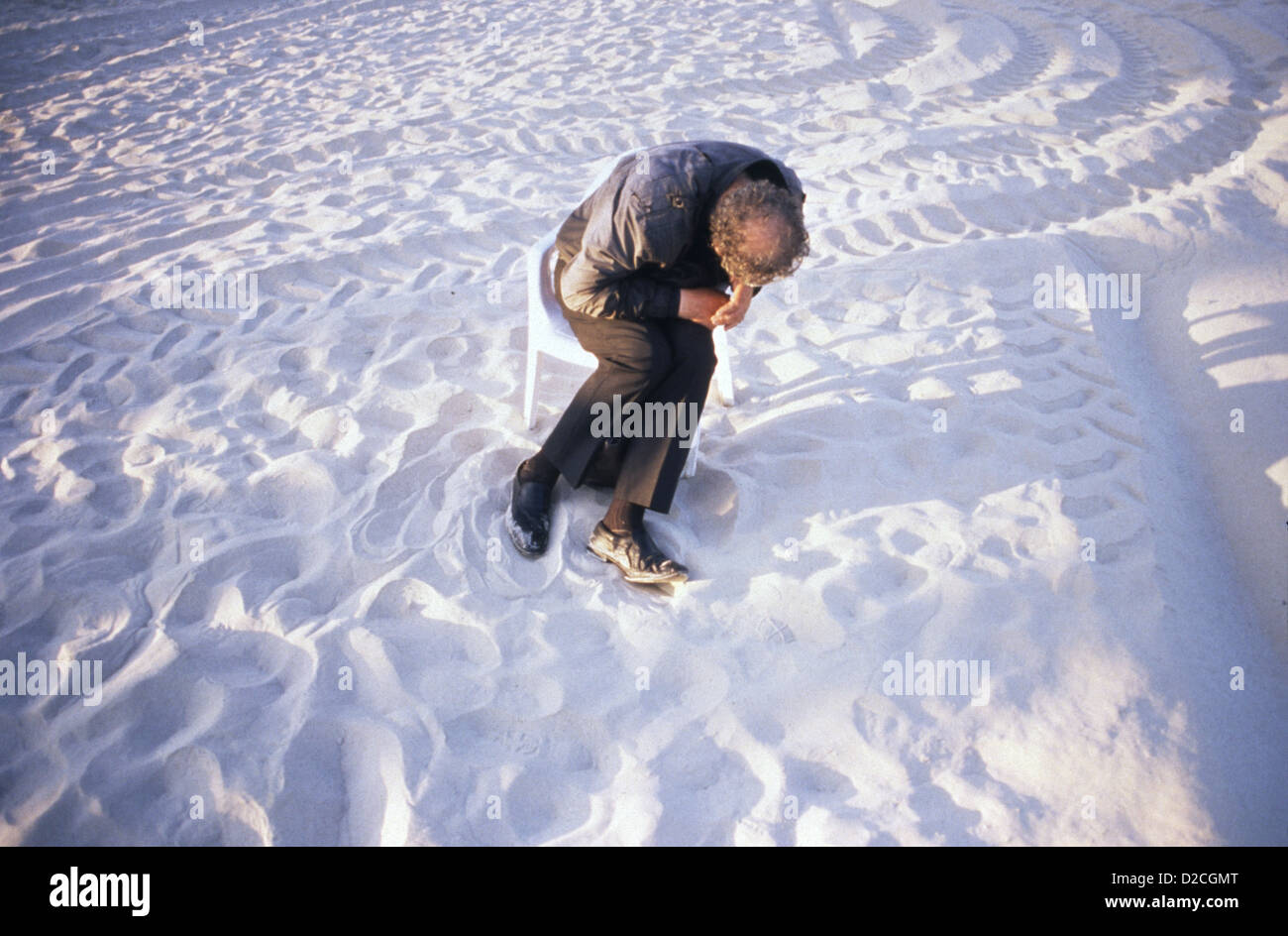 Un vieil homme endormi sur une chaise à la plage à Tel Aviv ISRAËL Banque D'Images
