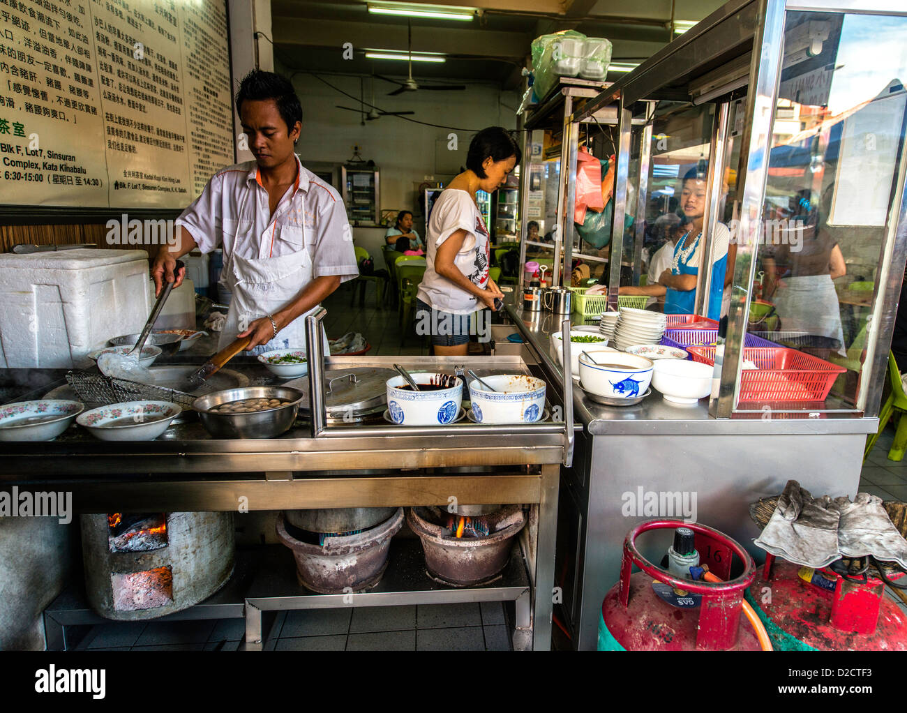 La cuisson des aliments de rue traditionnels de l'homme marché local Kota Kinabalu Sabah Malaisie Bornéo Banque D'Images