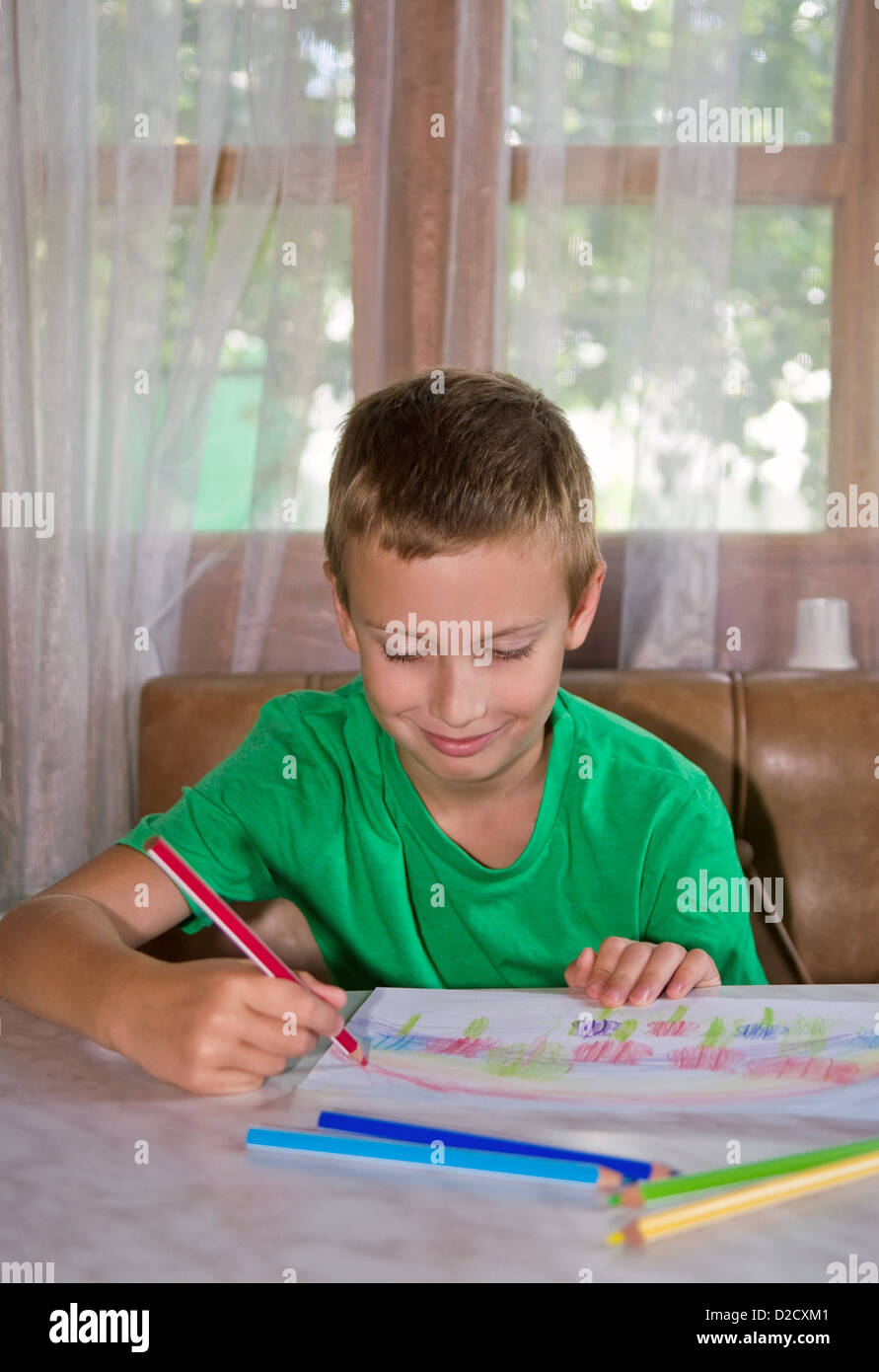 Young smiling boy drawing image positive de crayons Banque D'Images