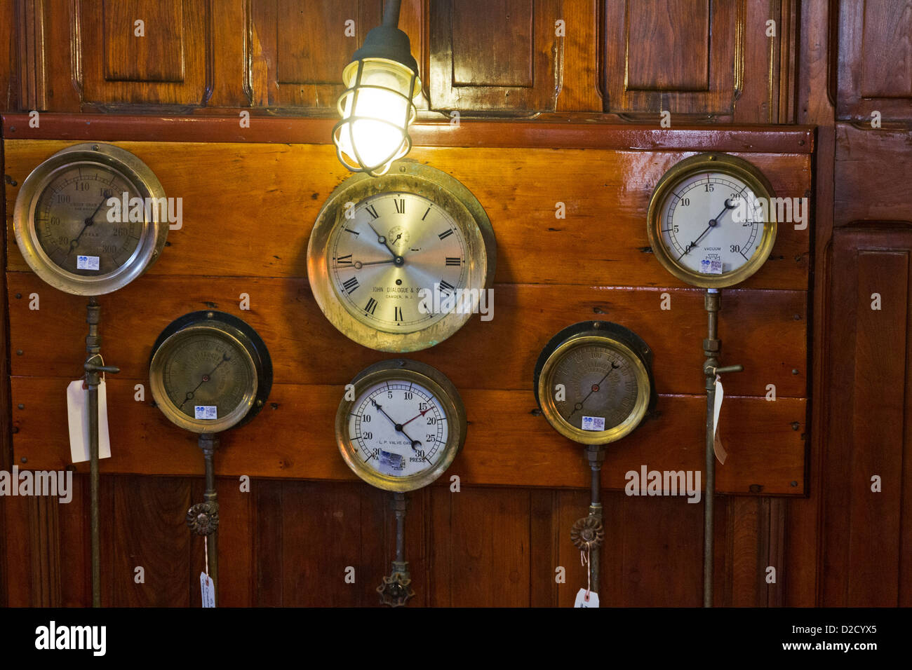 Les jauges et une horloge antique monté sur une cloison en bois à bord d'un bateau. Banque D'Images