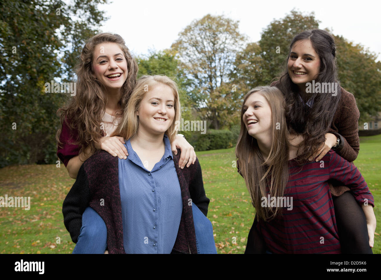 Les jeunes filles portant les uns les autres dans le parc Banque D'Images