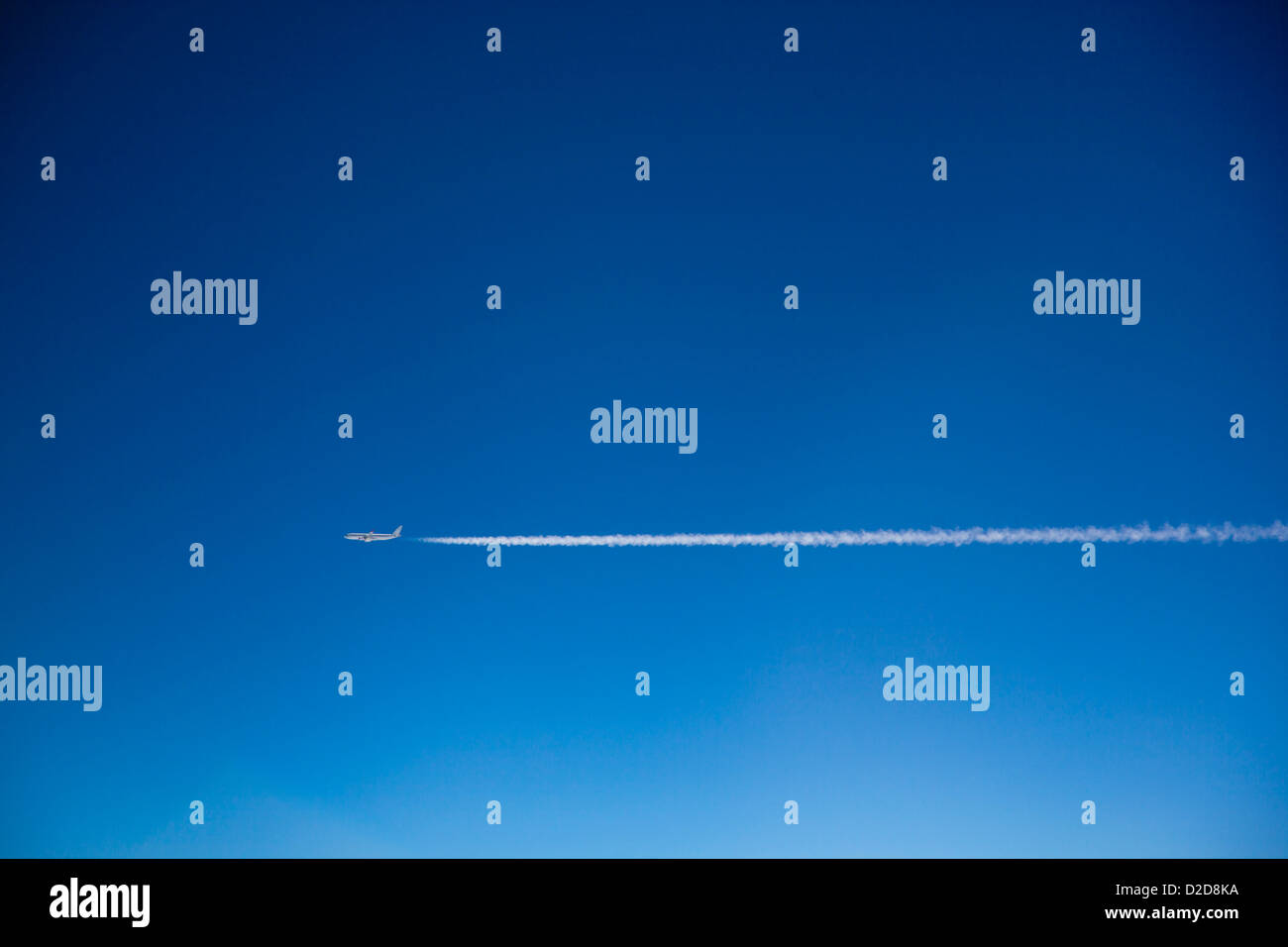 Un avion et des traînées de vapeur dans le ciel Banque D'Images