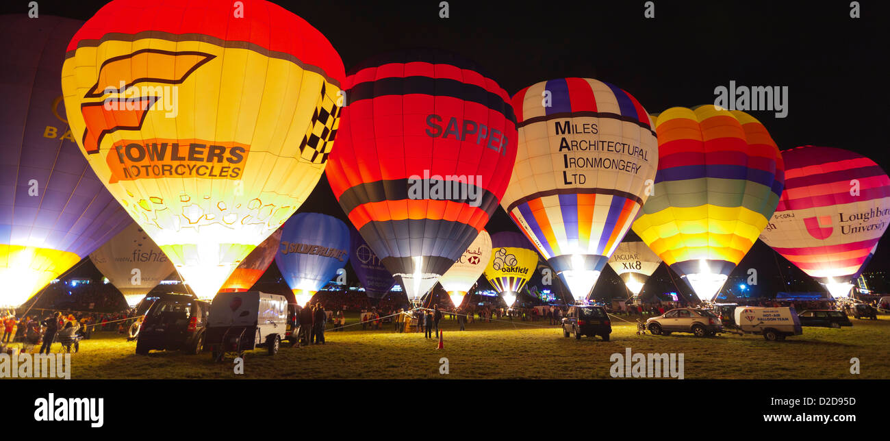 Bristol, Royaume-Uni - 13 août 2011 : une ligne de ballons à air chaud la nuit des bougies de préchauffage sur le Bristol Balloon Fiesta à Ashton Court. Banque D'Images