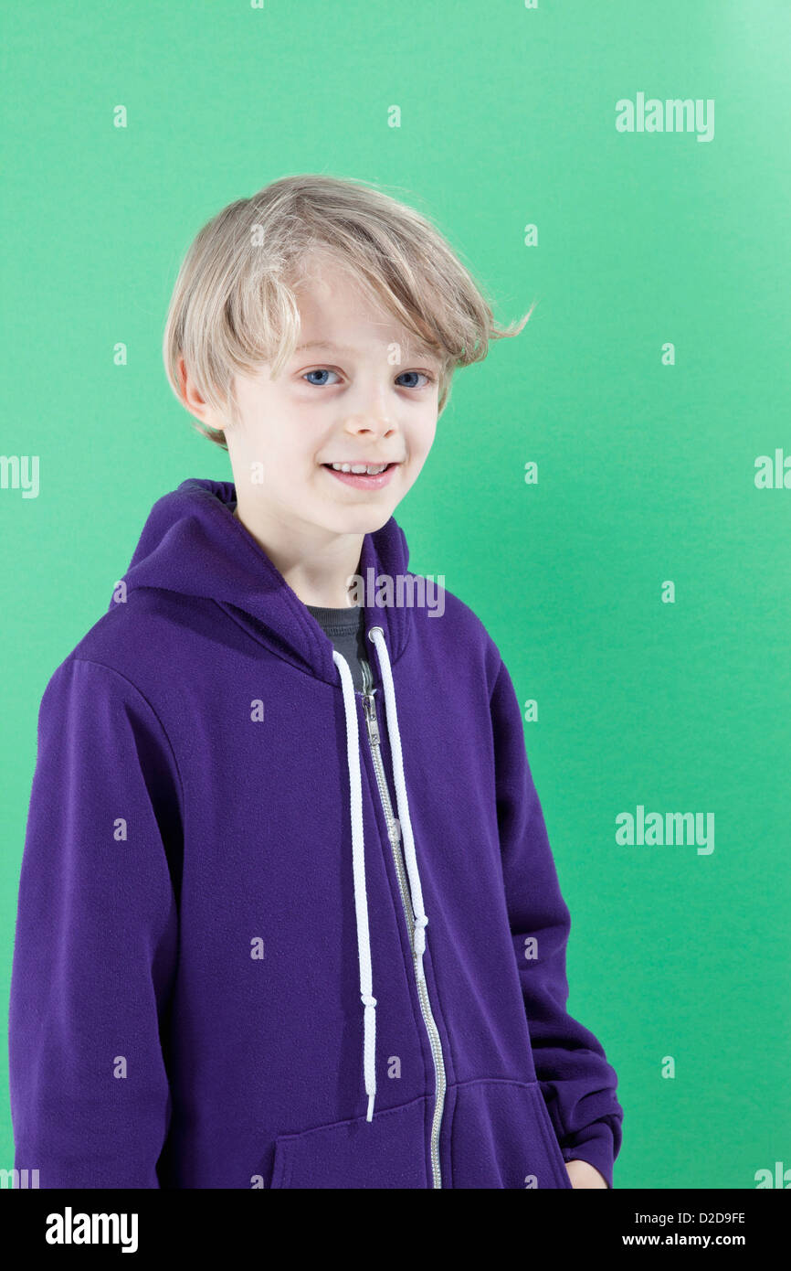Un garçon dans un sweat à capuche violet smiling at camera Banque D'Images