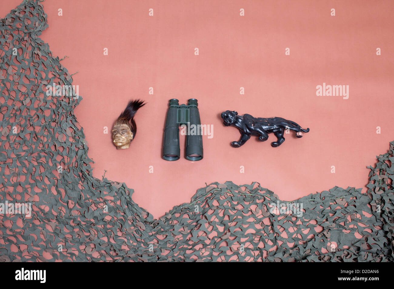 Une tête réduite, des jumelles, un jaguar et filet de camouflage Banque D'Images