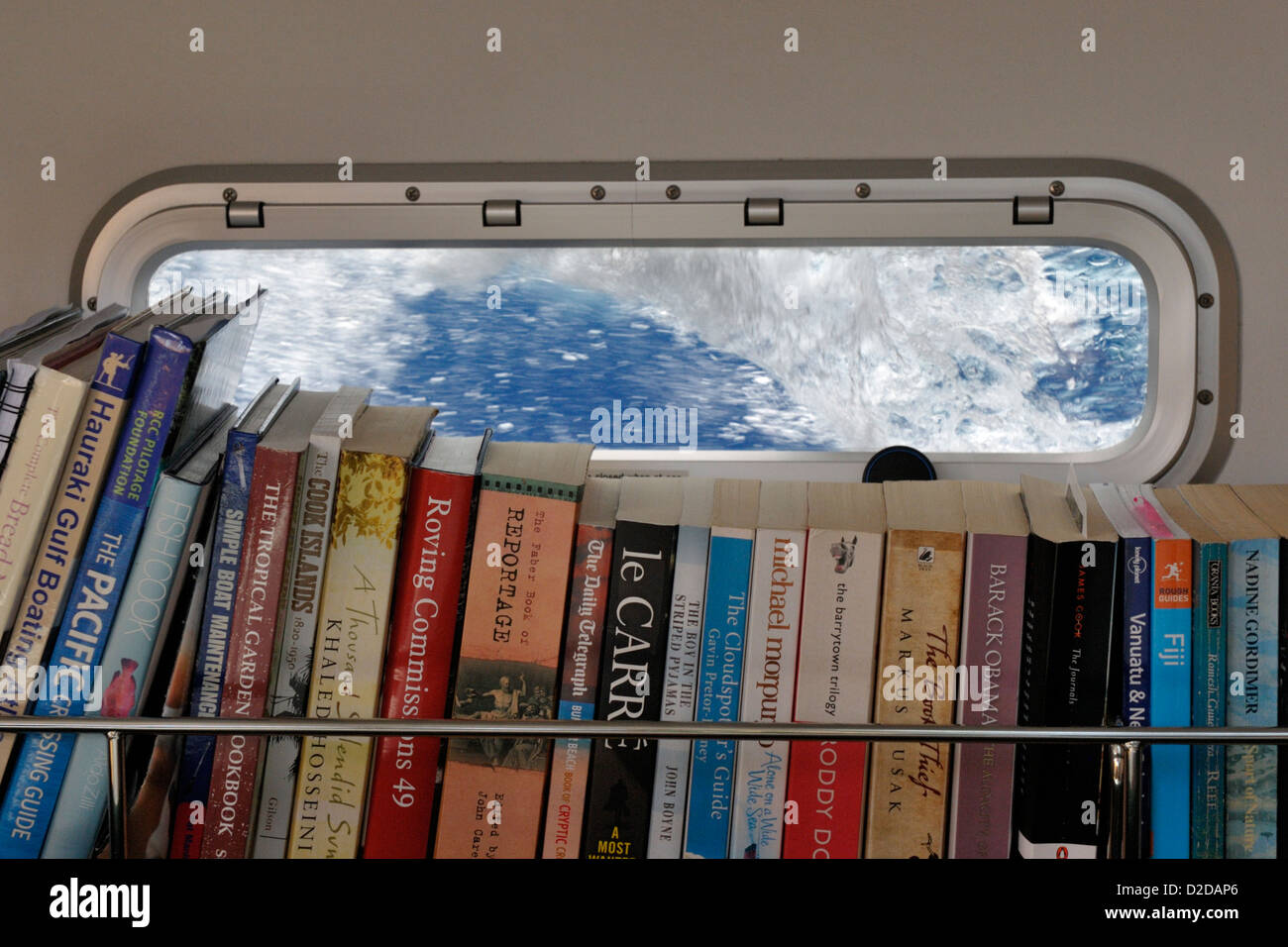 Un yacht à's saloon étagère et porthlight avec grande vague briser à l'extérieur, pendant une mer voile de Nouvelle-Zélande aux tropiques Banque D'Images