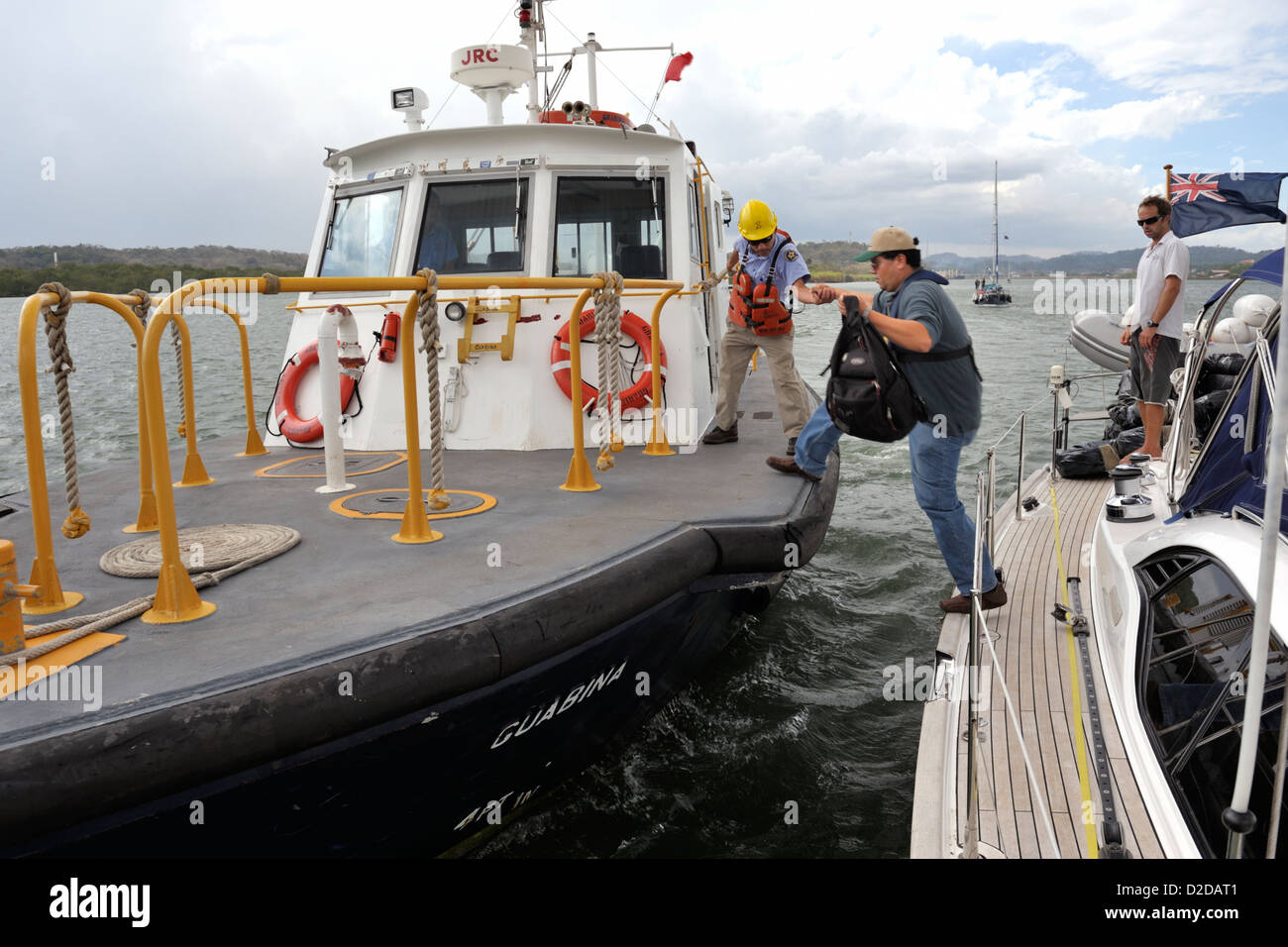 Un canal de Panama advisor sautant sur un bateau-pilote, aux côtés d'un yacht de croisière pacifique à la fin du Canal de Panama, après un transit du canal de Panama Banque D'Images