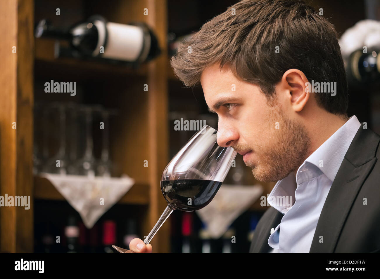 L'homme en goûtant un verre de vin rouge Banque D'Images