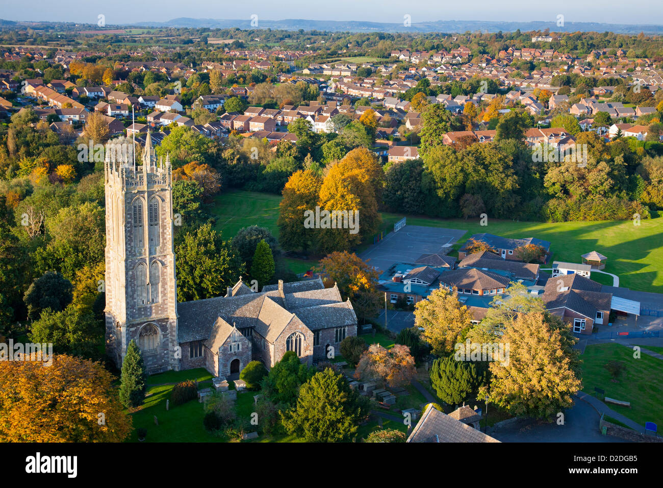 Vue aérienne d'un village anglais avec ancienne église, petite école et maisons modernes situé dans la campagne britannique. Banque D'Images