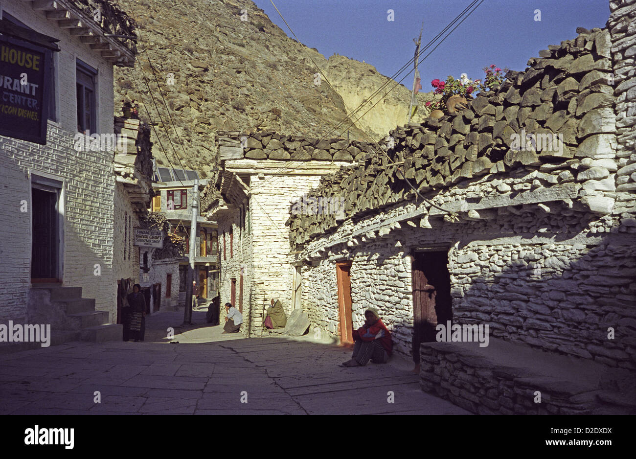 Les bâtiments blancs de la rue principale de Marpha dans la vallée de Kali Gandaki sur circuit de l'Annapurna au Népal avec bois de chauffage empilé sur les toits Banque D'Images