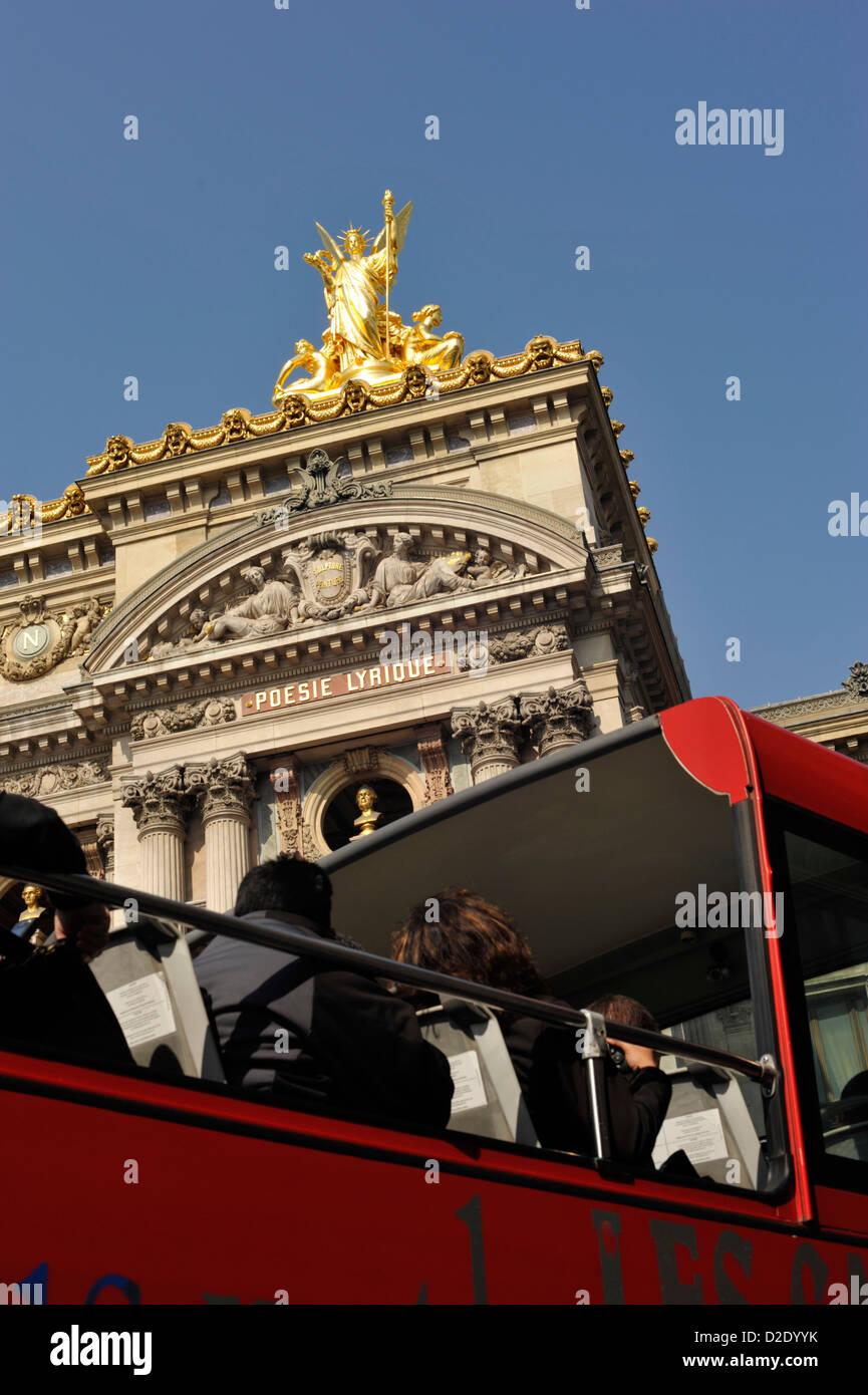 Les touristes sur le pont supérieur d'un bus panoramique passant l'Opéra de Paris France Banque D'Images